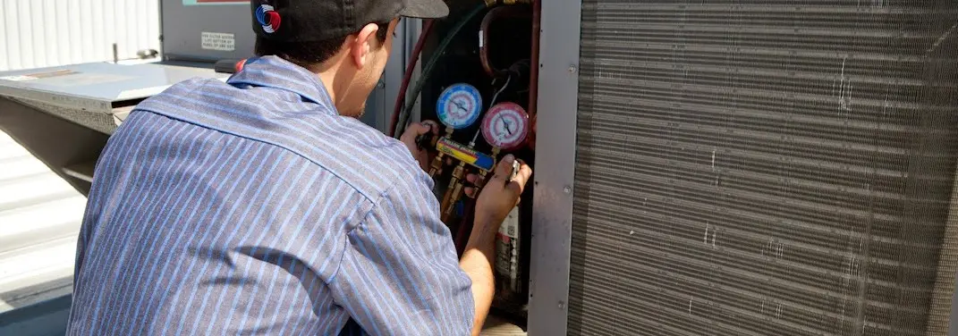 HVAC technician servicing a condenser unit in Deale