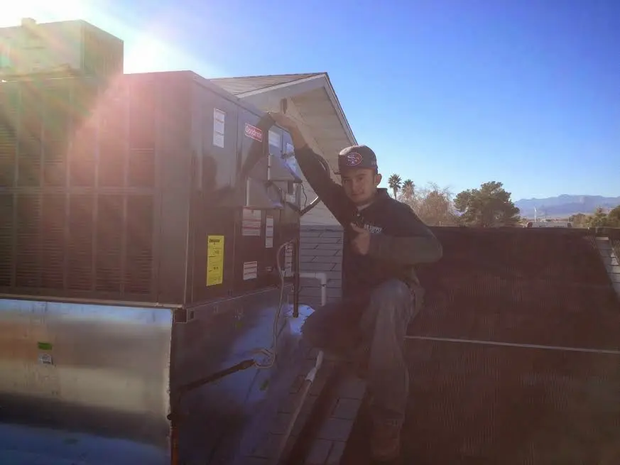 HVAC technician performing Heat Pump Repair on a rooftop unit in Deale